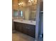 Bathroom with double vanity, framed mirrors and chandelier lighting at 20188 Tesoro Dr, Venice, FL 34293