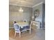 Cozy dining room with a chandelier, round table, four chairs and sideboard at 20188 Tesoro Dr, Venice, FL 34293