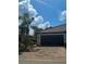 Charming home featuring a clay tile roof, brick driveway and tropical landscaping with a palm tree in front at 20188 Tesoro Dr, Venice, FL 34293