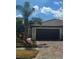 Charming home featuring a clay tile roof, brick driveway and tropical landscaping with a palm tree in front at 20188 Tesoro Dr, Venice, FL 34293