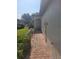 Paver walkway leads to a covered front entry showcasing professional landscaping with mature shrubbery at 20188 Tesoro Dr, Venice, FL 34293