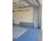 Spacious garage featuring a painted floor, overhead shelving, and ample storage space at 20188 Tesoro Dr, Venice, FL 34293