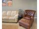 Cozy living room featuring a leather sofa, chair and coastal wall art at 20188 Tesoro Dr, Venice, FL 34293