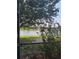 Beautiful lake view from the screened-in patio, framed by vibrant hibiscus bushes and mature trees at 20188 Tesoro Dr, Venice, FL 34293