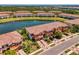 Aerial view of townhomes with a lake, lush landscaping, and private driveways in a well-maintained community at 20237 Lagente Cir, Venice, FL 34293