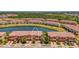 Aerial view of townhomes overlooking a tranquil lake surrounded by lush landscaping and mature trees at 20237 Lagente Cir, Venice, FL 34293
