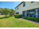 Spacious backyard with manicured lawn, lush landscaping, and screened lanai at 20237 Lagente Cir, Venice, FL 34293