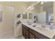 Bathroom featuring double sinks, a large mirror, and tiled flooring at 20237 Lagente Cir, Venice, FL 34293