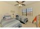 Bright bedroom featuring two twin beds with striped bedding, nautical decor and a ceiling fan at 20237 Lagente Cir, Venice, FL 34293
