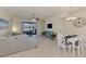 Open-concept living area with a cozy couch, modern furnishings, and a dining space with ample seating at 20237 Lagente Cir, Venice, FL 34293