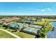 Aerial view of well-maintained tennis and pickleball courts next to the lake and community amenities at 20237 Lagente Cir, Venice, FL 34293