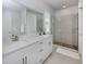 Bright bathroom features a double vanity with white countertops and glass enclosed shower at 20285 Symphony Pl, Venice, FL 34293