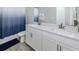 Modern bathroom with double vanity, white cabinets and drawers, stylish countertops, and wood look flooring at 20285 Symphony Pl, Venice, FL 34293