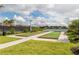 Outdoor bocce ball courts by a tranquil lake, complemented by green lawns and mature trees at 20285 Symphony Pl, Venice, FL 34293