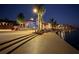 Inviting evening scene showcasing boardwalk, palm trees, and ambient lighting, highlighting community gathering spaces at 20285 Symphony Pl, Venice, FL 34293