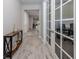 Hallway featuring wood look tile flooring, view to kitchen and dining areas, and an office space at 20285 Symphony Pl, Venice, FL 34293