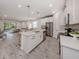 Bright, open kitchen with white cabinets, stainless steel appliances, and a large center island at 20285 Symphony Pl, Venice, FL 34293