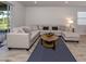 Inviting living room showcasing a large sectional couch, stylish rug, and neutral color palette at 20285 Symphony Pl, Venice, FL 34293