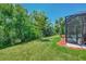 Lush backyard featuring a screened-in patio, palm trees, and vibrant green grass at 20290 Lagente Cir, Venice, FL 34293