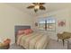 A cozy bedroom featuring a striped comforter and a window with a coastal view at 20290 Lagente Cir, Venice, FL 34293