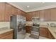 Modern kitchen features stainless steel appliances, granite counters, and wood cabinetry at 20290 Lagente Cir, Venice, FL 34293