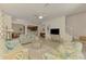 Bright living room featuring comfortable seating, tile floors, and an open layout to the kitchen and dining area at 20290 Lagente Cir, Venice, FL 34293