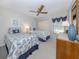 This bedroom features twin beds, a ceiling fan, light gray paint, and a window with blue valances at 229 Southampton Drive # 290, Venice, FL 34293