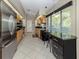 Bright kitchen with stainless appliances, stone countertops, tile floors, and natural wood cabinetry at 229 Southampton Drive # 290, Venice, FL 34293