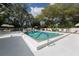 An in-ground swimming pool has blue steps with patio furniture and umbrellas surrounding it at 229 Southampton Drive # 290, Venice, FL 34293