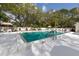 Large community swimming pool surrounded by chairs, umbrellas, and mature shade trees at 229 Southampton Drive # 290, Venice, FL 34293