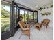 Sunroom with tiled floor, ceiling fan, and wicker furniture that looks out to the lawn at 229 Southampton Drive # 290, Venice, FL 34293