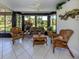 Sunroom with tiled floor, ceiling fan, and wicker furniture that looks out to the lawn at 229 Southampton Drive # 290, Venice, FL 34293