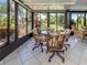 Sunroom with tiled floor and floor-to-ceiling windows looking out to the lush exterior landscaping at 229 Southampton Drive # 290, Venice, FL 34293