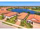 Terracotta roof homes surround a beautiful lake and nature preserve in an aerial community view at 23494 Copperleaf Dr, Venice, FL 34293