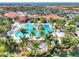 Aerial view of a large community pool surrounded by palm trees and lounge chairs at 23494 Copperleaf Dr, Venice, FL 34293