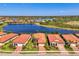 Aerial view of homes with terracotta roofs surrounding a beautiful lake and nature preserve at 23494 Copperleaf Dr, Venice, FL 34293