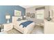 Cozy bedroom with white furniture, blue accent wall, and natural light at 23494 Copperleaf Dr, Venice, FL 34293