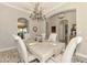 Elegant dining area with seating for six, a modern chandelier, and views to other rooms at 23494 Copperleaf Dr, Venice, FL 34293