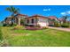 Charming home featuring a terracotta roof, lush landscaping, and a two-car garage at 23494 Copperleaf Dr, Venice, FL 34293