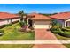 Home exterior featuring a terracotta roof, lush landscaping, and brick paver driveway at 23494 Copperleaf Dr, Venice, FL 34293