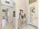 Light-filled foyer with tiled floor and decorative console table next to a glass front door at 23494 Copperleaf Dr, Venice, FL 34293