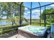 Luxurious hot tub on a screened-in patio, offering serene lake views and lush landscaping for ultimate relaxation at 23494 Copperleaf Dr, Venice, FL 34293