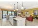 Bright kitchen features a large island, seamless access to the waterfront patio, and comfortable living space at 23494 Copperleaf Dr, Venice, FL 34293