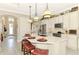 Bright kitchen offers seating at the spacious island, modern lighting, and easy access to the front entrance at 23494 Copperleaf Dr, Venice, FL 34293