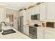Well-equipped kitchen boasts stainless steel appliances, white cabinetry, and an adjacent dining area at 23494 Copperleaf Dr, Venice, FL 34293