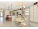 Bright kitchen features a large island with seating, white cabinetry, and a dining area with wicker chairs at 23494 Copperleaf Dr, Venice, FL 34293