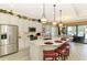 Bright kitchen features a large island with seating and stainless steel appliances, with access to a waterfront patio at 23494 Copperleaf Dr, Venice, FL 34293