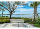 Relaxing lake view from a park bench, framed by trees and manicured greenery at 23494 Copperleaf Dr, Venice, FL 34293