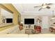 Comfortable living room with a white leather sectional, large TV, and barstool seating at the kitchen island at 23494 Copperleaf Dr, Venice, FL 34293