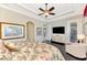 Bright main bedroom features tray ceiling, ceiling fan, large window, and hardwood floors at 23494 Copperleaf Dr, Venice, FL 34293